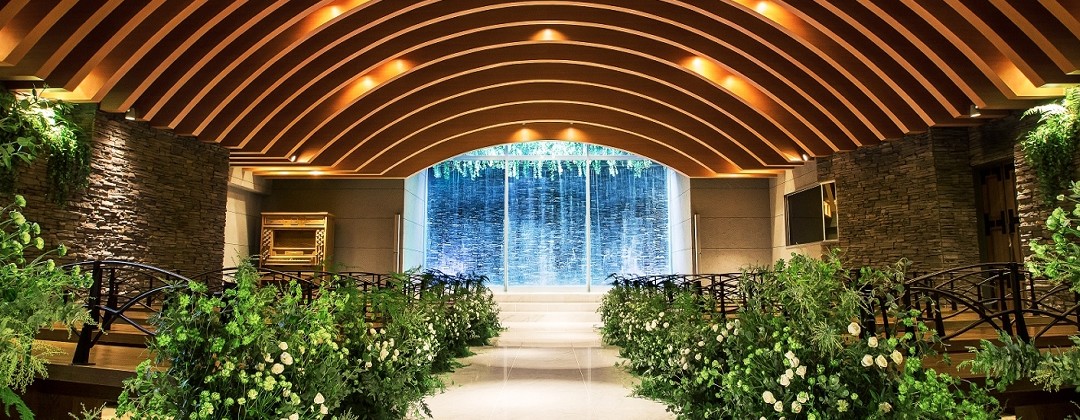 GLOBAL WEDDING DIADE(グローバルウエディング ディアーデ)。挙式会場。正面に滝が流れ、森の中の教会のような雰囲気の式場では、教会式と人前式に対応。100名まで着席できます
