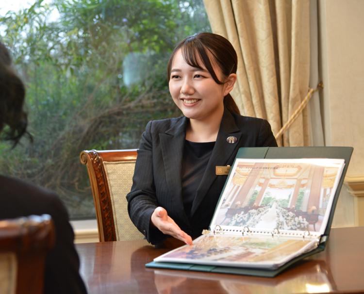 リーガロイヤルホテル東京。スタッフ。イメージがわきやすいよう資料を交えながら説明するプランナー