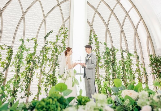 アルマリアンTOKYO（アヴェニールクラスTOKYOと統合）。挙式会場。純白の空間にグリーンの装飾が映え、花嫁を一層際立たせます