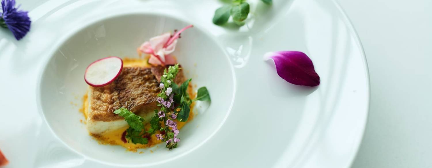 ルクリアモーレ六本木。料理。できたてならではの豊かな香りに心躍る、魚料理の逸品。あしらいに可憐な花びらを用いることで、美しさがより一層際立ちます