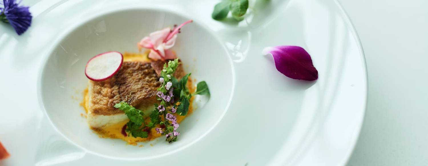 ルクリアモーレ アジュール竹芝。料理。素材の良さを活かした上品な味わいを堪能できる魚料理。花びらをあしらった美しい盛り付けも魅力的です
