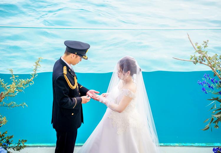 鴨川シーワールド（MOANI RESORT KAMOGAWA）。挙式会場。ブルーの水槽の前で純白のウェディングドレスが際立ちます