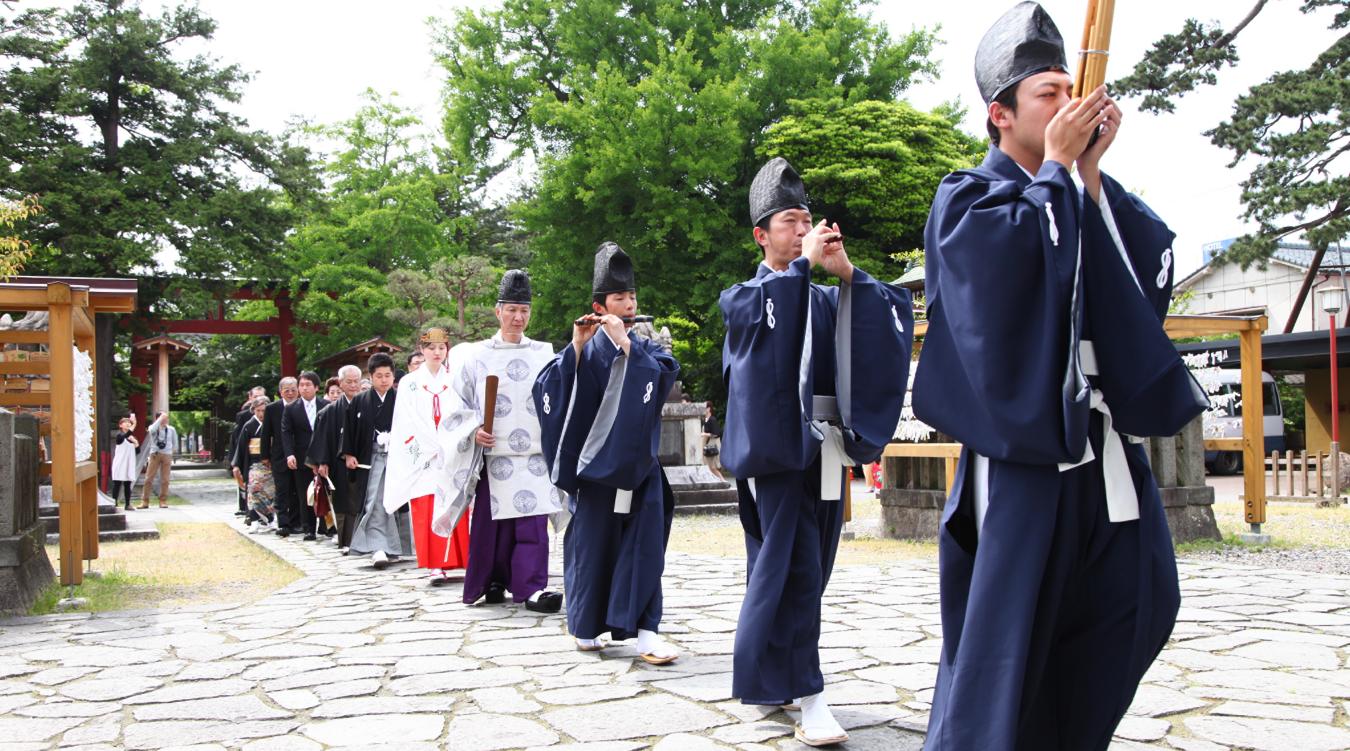 諏訪神社(新発田)。雅楽の奏者を先頭に、神主や巫女、新郎新婦、そして親族が列になって歩む参進。心地よい緊張感に包まれて本殿へと向かいます