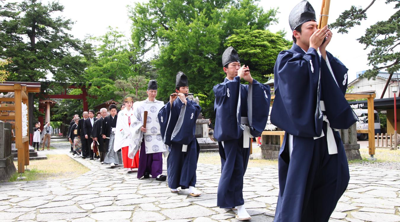 諏訪神社（新発田）。雅楽の奏者を先頭に、神主や巫女、新郎新婦、そして親族が列になって歩む参進。心地よい緊張感に包まれて本殿へと向かいます