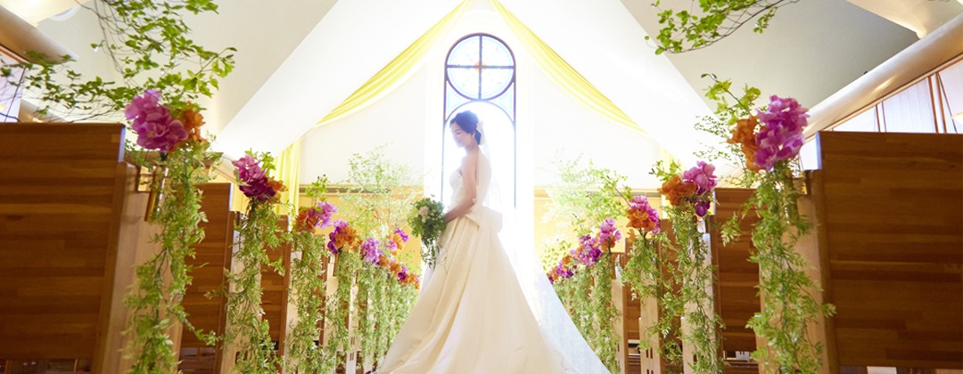 つま恋リゾート 彩の郷。挙式会場。緑の木々に佇む白い教会、『チャペルつま恋』。ステンドグラスから降り注ぐ淡い光が、神聖な挙式を演出してくれます