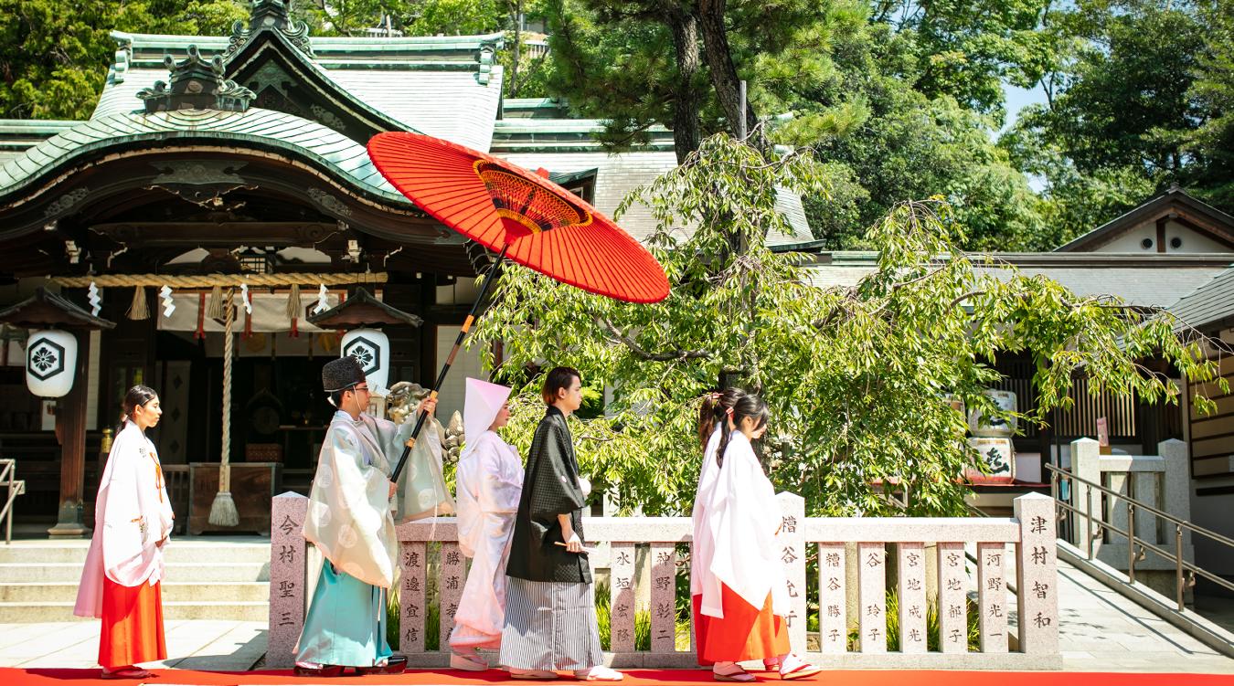 芦屋神社。豊かな緑と心地よい風に包まれながら、本殿へと続く参道を歩む新郎新婦。日本の伝統と格式を感じる厳かな神前式が執り行われます