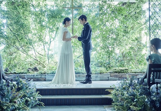 InStyle wedding KYOTO （インスタイルウェディング京都）。挙式会場。祭壇奥の美しいガラス窓を背景にした晴れやかなセレモニー