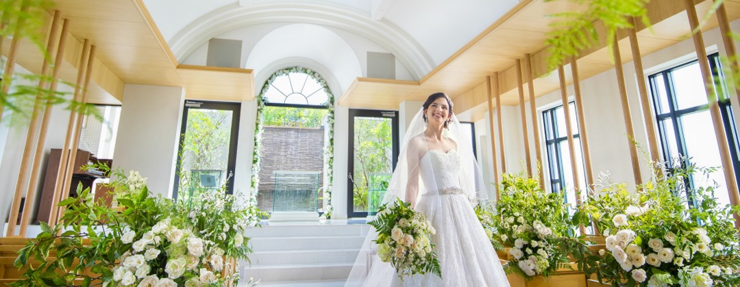 エミリア(Wedding Court EMILIA) 。挙式会場。広々と開放的なチャペルは、90名まで収容することが可能。祭壇奥に大きな窓があり、明るい光がたっぷり差し込みます
