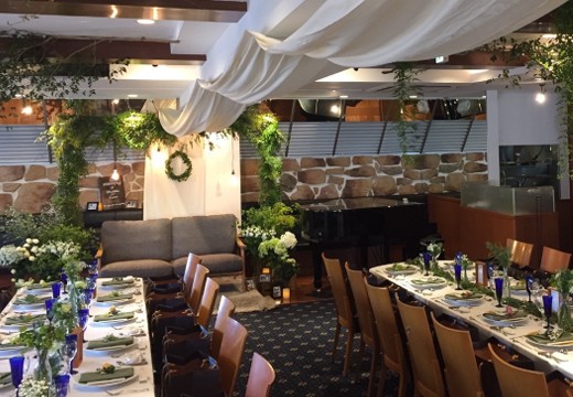 TO THE HERBS（トゥザハーブズ）。披露宴会場。落ち着いた照明と製花のグリーンでシックな印象に