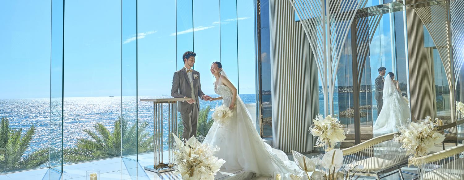 ヴォヤージュ ドゥ ルミエール Chatan Resort(ヴォヤージュ ドゥ ルミエール 北谷 リゾート)。挙式会場。天井が高く、祭壇の先には青く美しい海を臨む開放的なチャペル。最大62名のゲストを招待できます