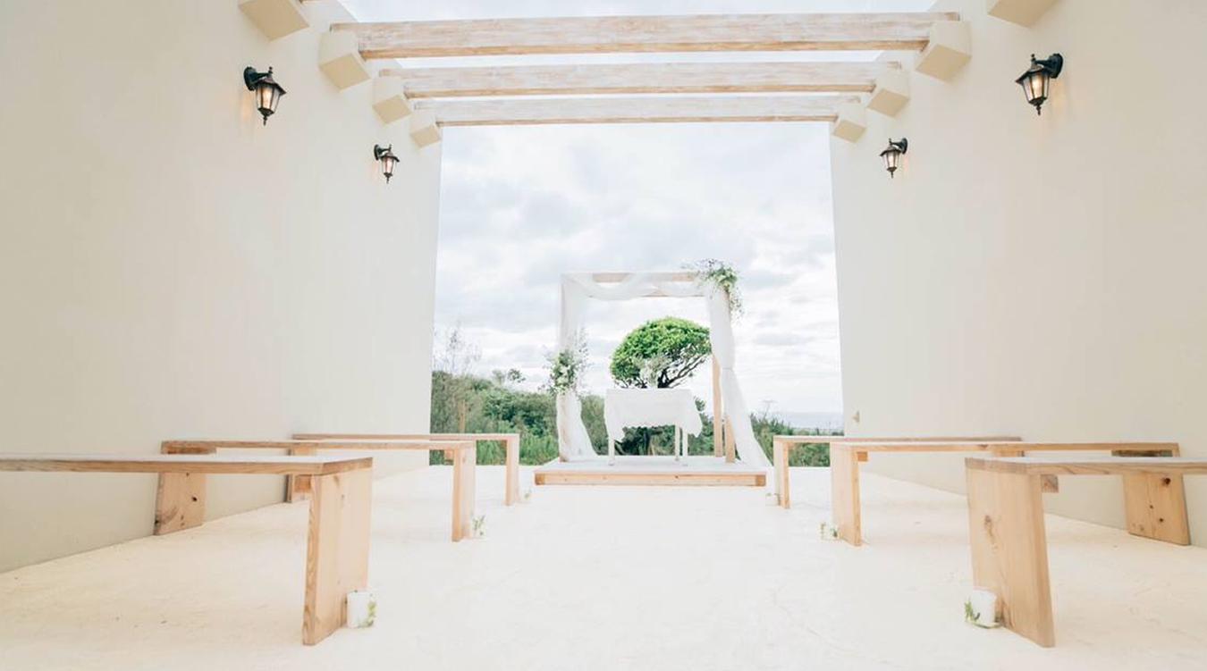 Auberge 皿の上の自然（オーベルジュ 皿の上の自然）。丘の上から見渡す沖縄の景色を背に執り行われるセレモニー。近しい人たちとの結婚式にぴったりのアットホームな会場です